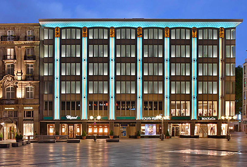 domcarre-koeln-retail-geschaefte-abend Blick auf luxuriöse Geschäfte in einer Fußgängerzone am Abend