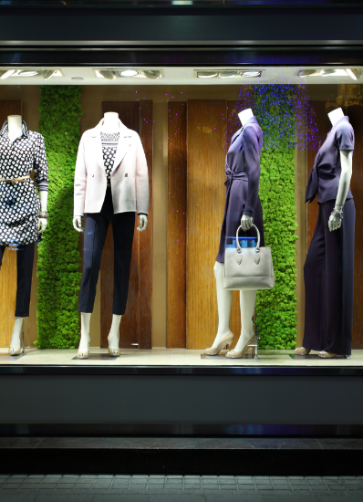 domcarre-koeln-retail-schaufenster-kleidung Schaufenster mit einer ansprechenden Anordnung von Schaufensterpuppen in verschiedenen Outfits.